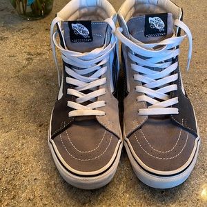 Vans of the wall high tops.  Multi color including grays, blacks and white.